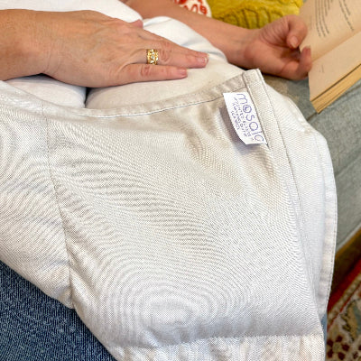 Close view of a person reading with a white Coolmax weighted lap blanket