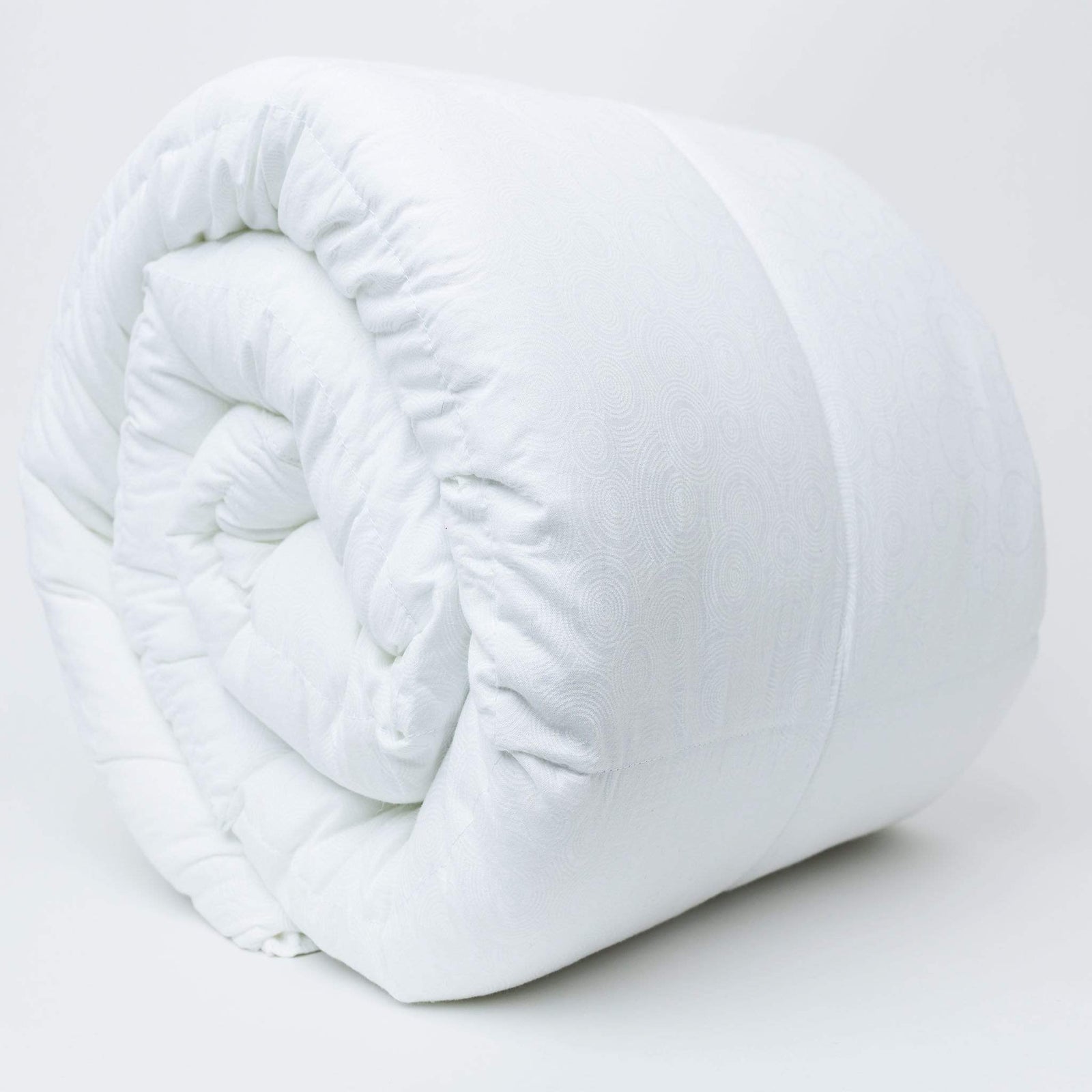 Close view of a rolled white cotton blanket showing its stitched pocket construction
